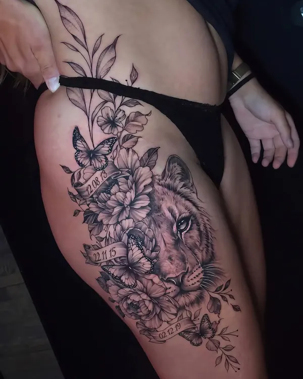 Client's reference photo: a floral thigh tattoo with a lioness and butterflies